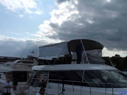 Sealine F42 bimini with a curved design, featuring Sunbrella fabric and stainless steel frame for flybridge protection.