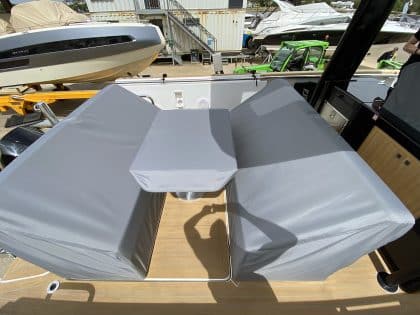 Fjord 38 XP with custom seating, table, and console covers installed for protection and style.